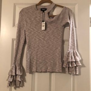 Cream shirt with exposed shoulder and ruffles